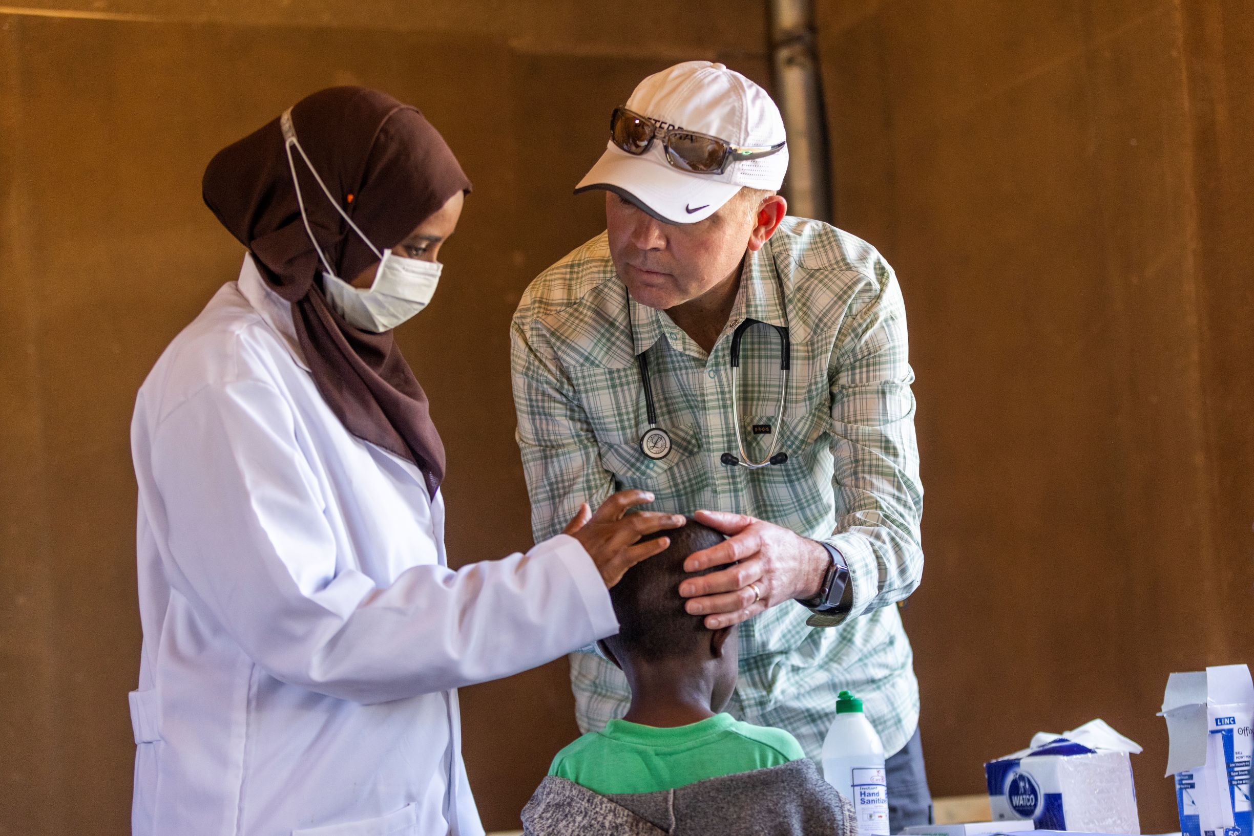 Dr. Osguthorpe assesses a child while training a local doctor.
